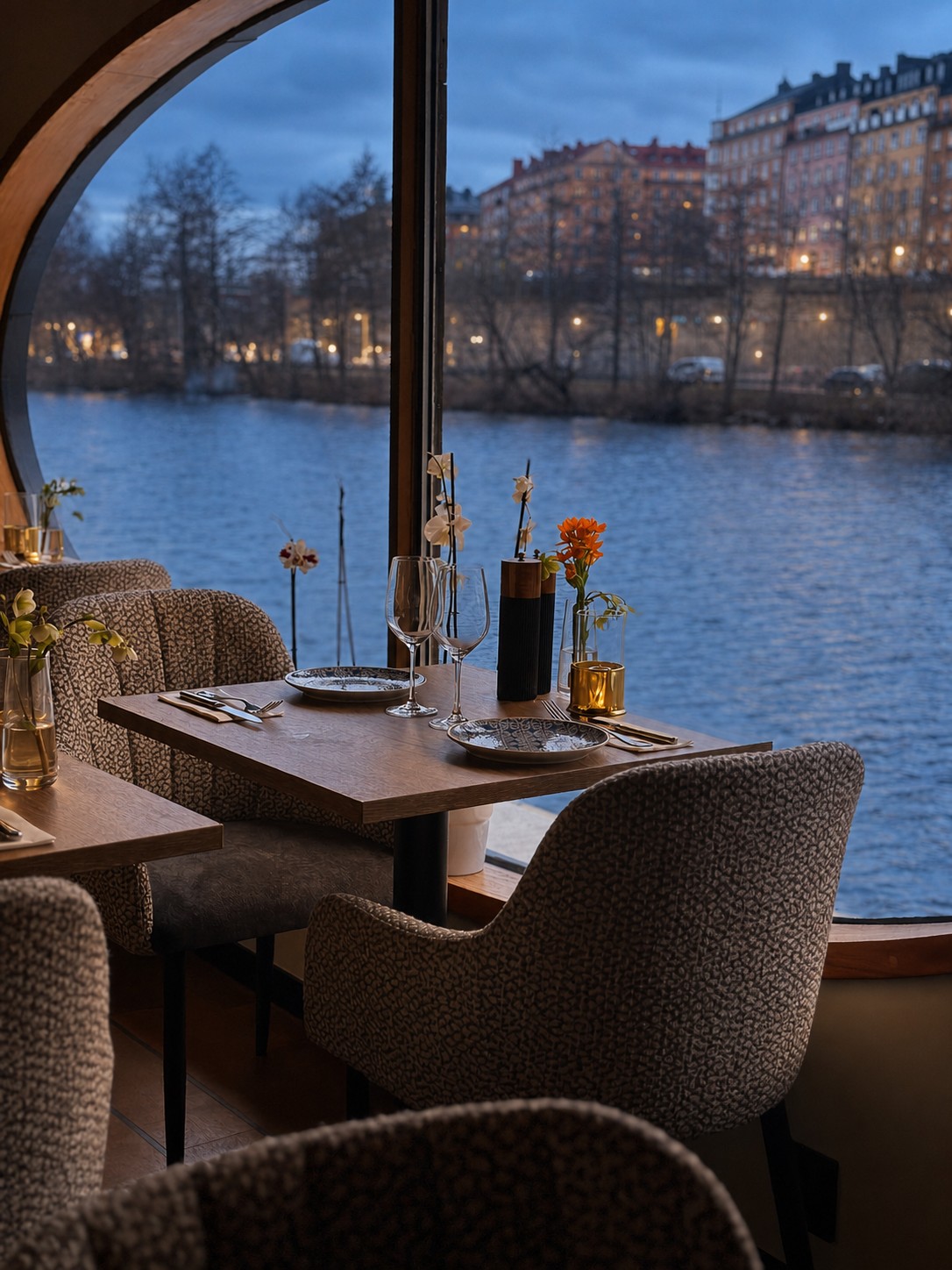 Gusto Barca med dukat bord vid det runda fönstret mot vattnet